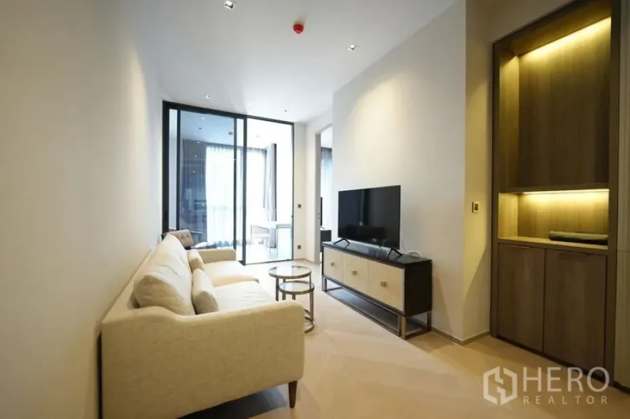 Condominium for rent - Airy living room view with sofa, TV stand and sliding glass doors to a bright study.