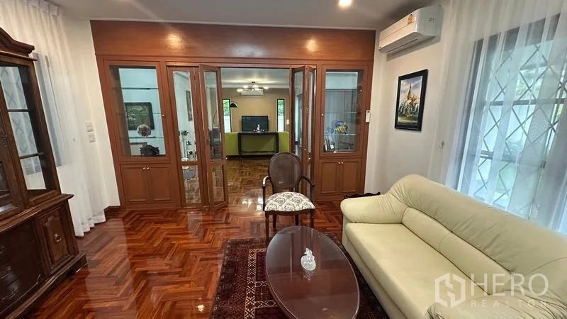 独立式住宅 出租在Watthana, Bangkok - 独立起居室，内置玻璃柜与沙发。