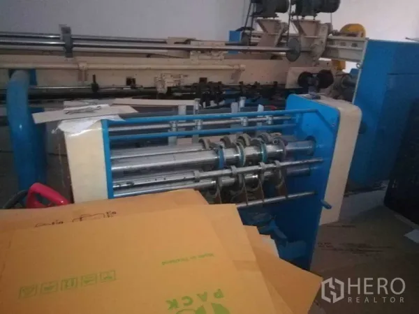 Factory for sale in Bang Len, Nakhon Pathom - Close-up of conveyor and cutting equipment for packaging production.