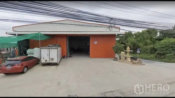 คลังสินค้า ให้เช่าในBang Kapi, Bangkok - ด้านหน้าโกดังสีแดง ประตูทางเข้าเปิดกว้าง พร้อมลานโหลดคอนกรีต