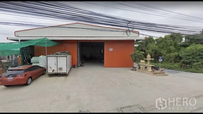 คลังสินค้า ให้เช่าในBang Kapi, Bangkok - ด้านหน้าโกดังสีแดง ประตูทางเข้าเปิดกว้าง พร้อมลานโหลดคอนกรีต