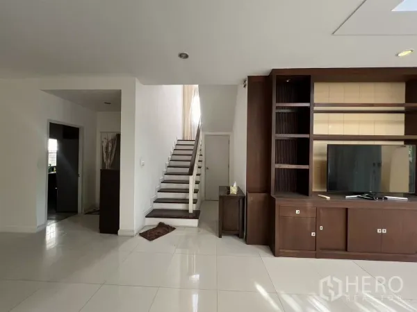 Detached House for rent in Bang Kapi, Bangkok - Open living area leading to a wooden staircase and storage under stairs.