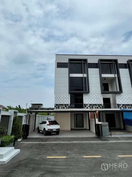 Home Office for rent in Khan Na Yao, Bangkok - Modern three-storey home office facade with covered parking and driveway in Khan Na Yao.