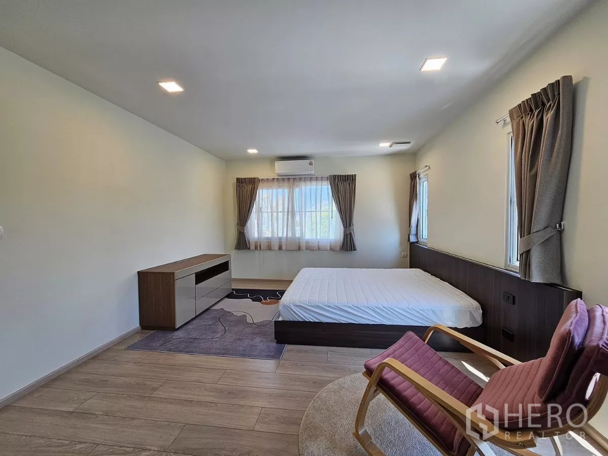 Detached House for rent in Bang Phli, Samut Prakan - Spacious master bedroom with large windows, bed and seating area.