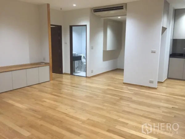 公寓 for 在Watthana, Bangkok - 开放式客厅，浅色木地板，内置储物台与通往浴室的门。