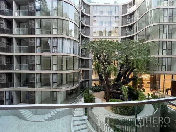 คอนโด ให้เช่าในKhlong Toei, Bangkok - อาคารคอนโดกระจกโค้งพร้อมสวนลานภายในและต้นไม้ใหญ่