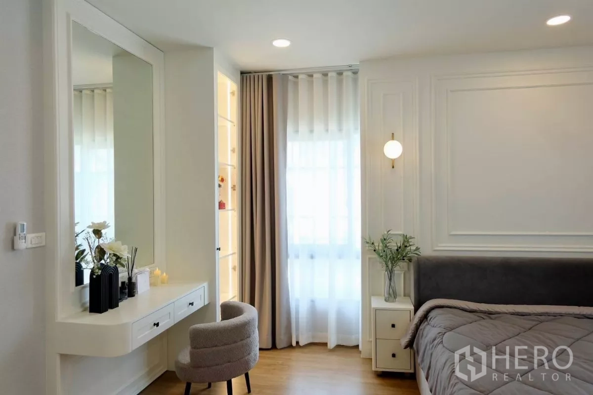 Detached House for sale in Bang Phli, Samut Prakan - Master bedroom with paneled feature wall, bedside table, built-in vanity and floor-to-ceiling curtains