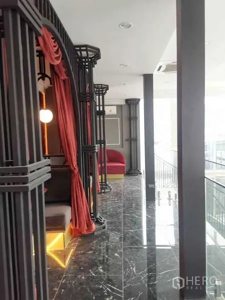 零售空间 出租 - 楼层走廊，黑色框架与红色帘幕，黑色大理石地面与卡座