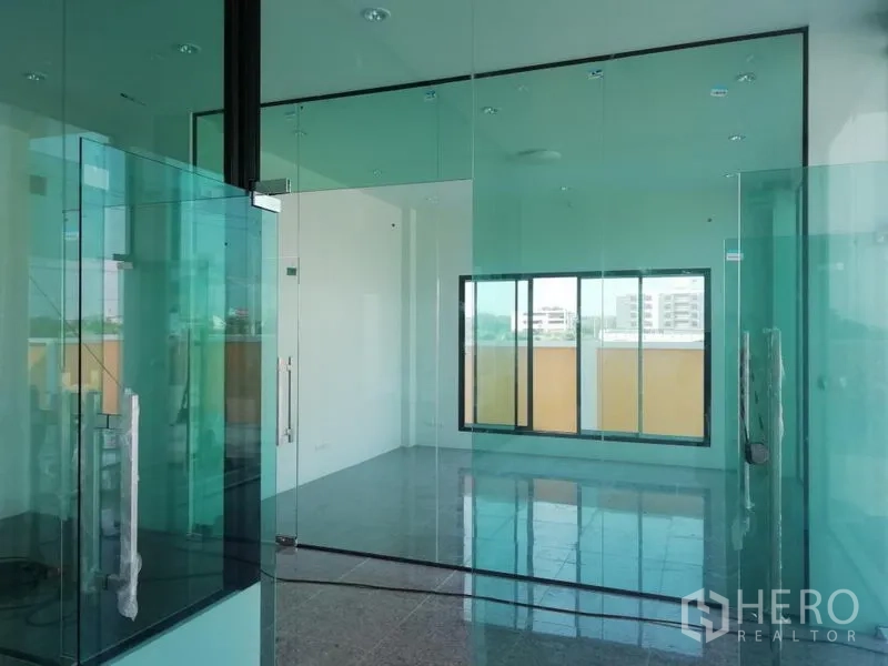 Factory for sale in Bang Pakong, Chachoengsao - Glass-walled office and meeting room with tinted partitions and large view windows.