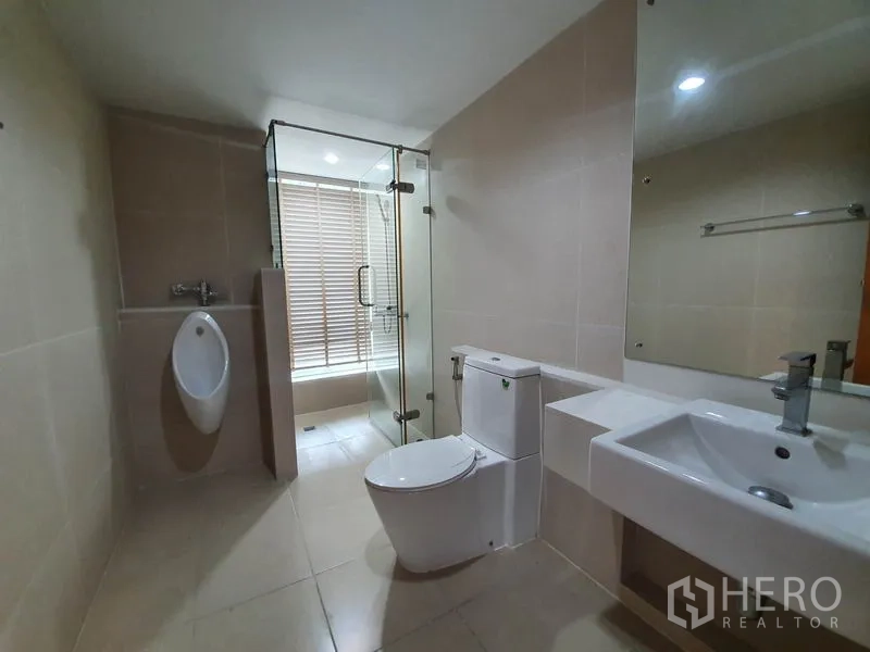 คอนโด ให้เช่าในRatchathewi, Bangkok - ห้องน้ำสมัยใหม่พร้อมตู้ฝักบัวกระจก โถปัสสาวะ โถสุขภัณฑ์ และอ่างล้างหน้าทรงเหลี่ยม.