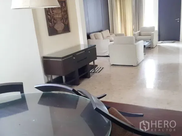Detached House for rent in Wang Thonglang, Bangkok - Open living and dining area with marble floors, neutral sofas, console table and large curtained windows.