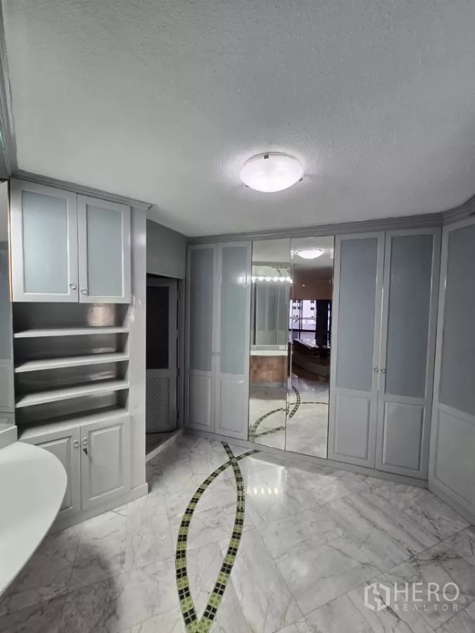 Condominium for rent in Pathum Wan, Bangkok - Walk-in dressing room with marble floors, mirrored wardrobes and built-in storage.