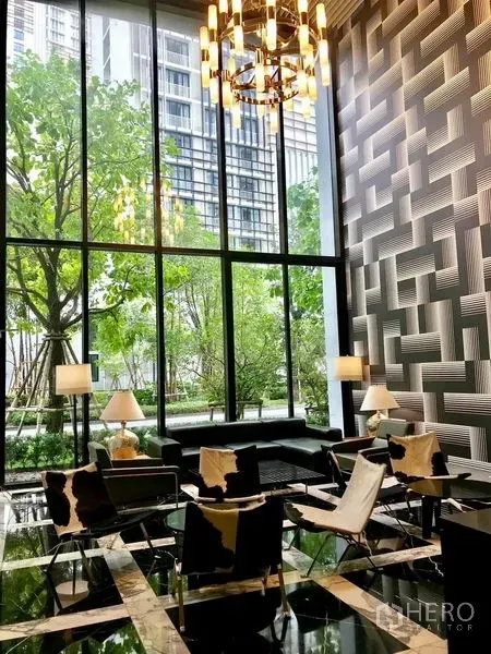 คอนโด ให้เช่าในKhlong Toei, Bangkok - ล็อบบี้เพดานสูง กระจกเต็มความสูง โคมระย้า และชุดโซฟามองออกสู่สวนเขียว