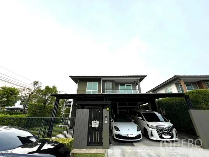 Townhouse for sale in Bang Khae, Bangkok - Modern two-storey townhouse with gated entry and a covered two-car carport.