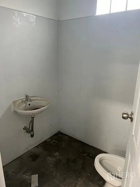 货栈 出租在Khlong Sam Wa, Bangkok - 仓库内简易卫生间，白色瓷砖墙、挂墙洗手盆与坐便器。