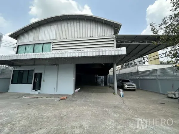 คลังสินค้า ให้เช่าในPak Kret, Nonthaburi - ด้านหน้าโกดังผนังเมทัลชีท มีหลังคาคลุมทางขนถ่ายและที่จอดรถ