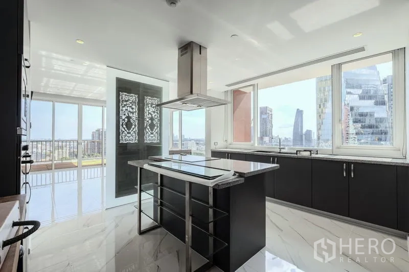 คอนโด ขาย - ครัวมีไอส์แลนด์และหน้าต่างบานใหญ่ เปิดสู่ระเบียงและวิวสกายไลน์เมือง