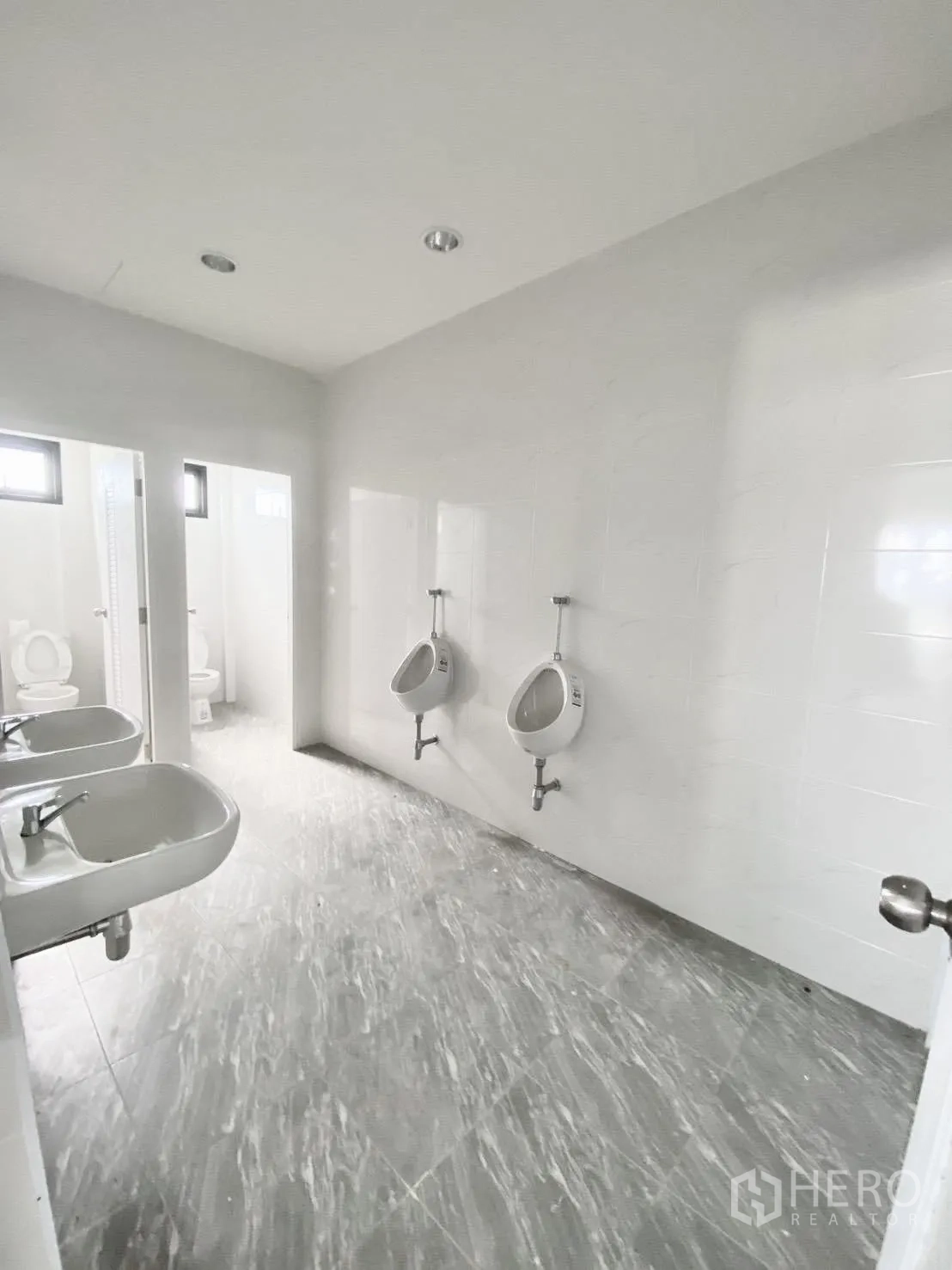 Warehouse for rent in Bang Bo, Samut Prakan - Restroom featuring urinals and basins with tiled walls and floor.
