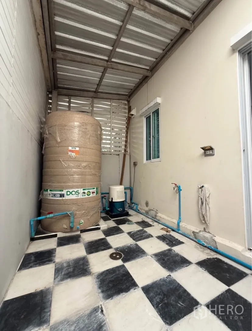 ทาวน์เฮาส์ ให้เช่าในSuan Luang, Bangkok - พื้นที่ซักล้างด้านหลัง มีถังเก็บน้ำ ปั๊มน้ำ และพื้นตาราง ใต้หลังคา