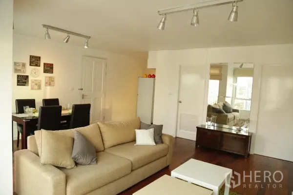 คอนโด ให้เช่าหรือขายในWatthana, Bangkok - พื้นที่นั่งเล่นแบบโอเพนแปลน โซฟาสีเบจ ชุดรับประทานอาหาร และไฟราง