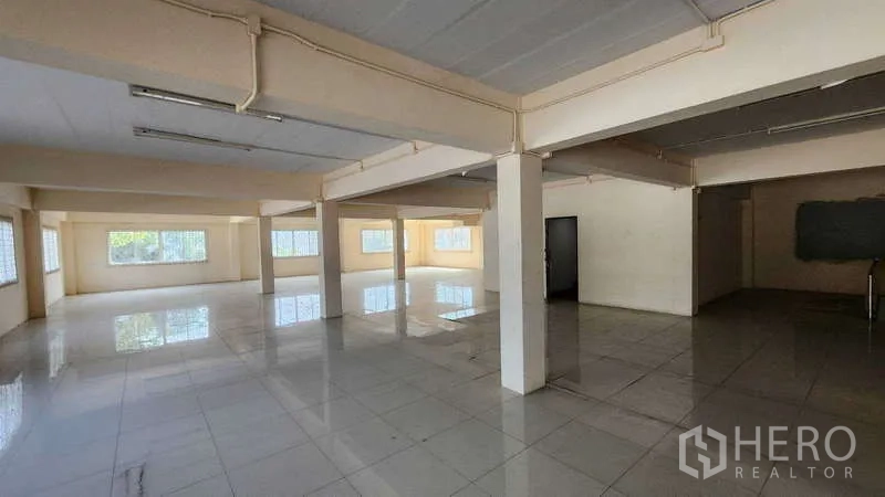 Factory for rent in Pak Kret, Nonthaburi - Open-plan office hall with tiled flooring, columns and natural light