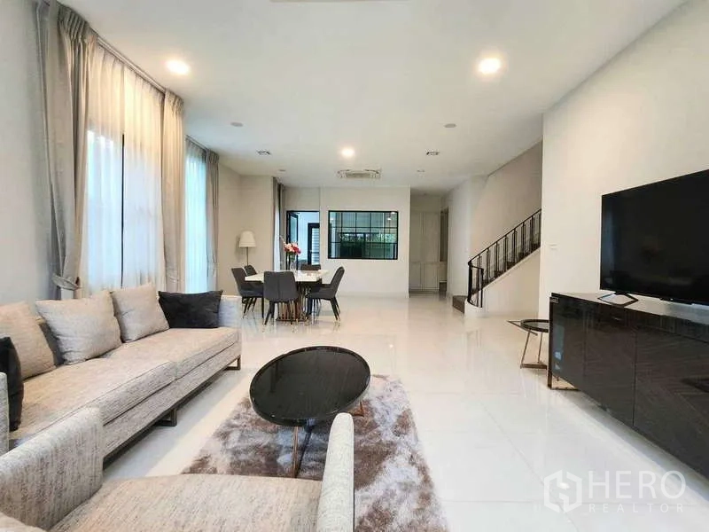 Detached House for rent in Saphan Sung, Bangkok - Living room perspective toward dining zone and staircase, bright and airy with neutral decor.