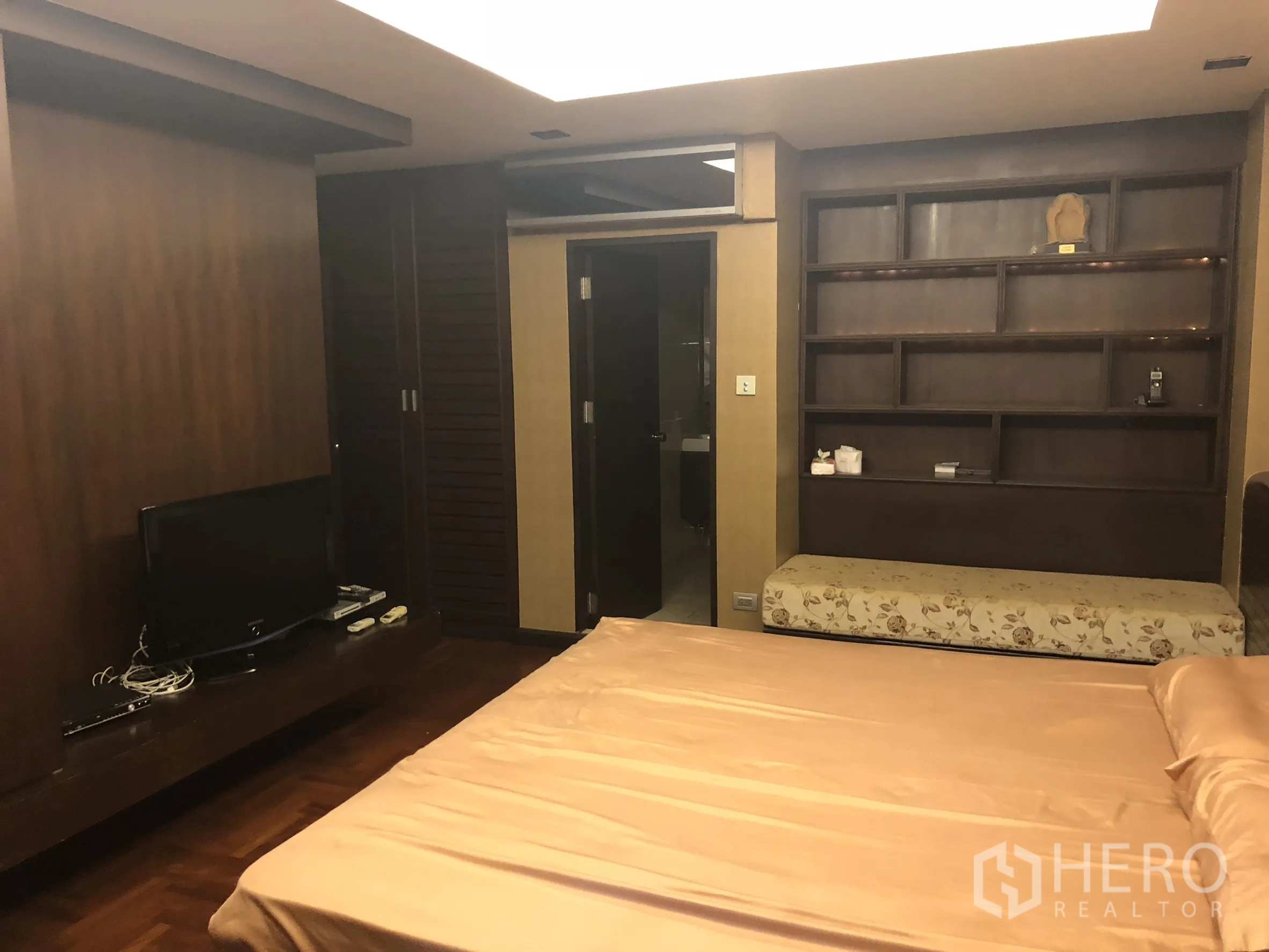 公寓 出租在Sathon, Bangkok - 宽敞主卧，设电视柜、衣柜、置物架，并通往浴室。