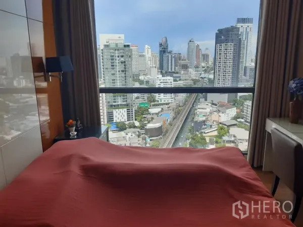 公寓 出租在Khlong Toei, Bangkok - 卧室配大幅观景窗，可见城市与轻轨线景致。