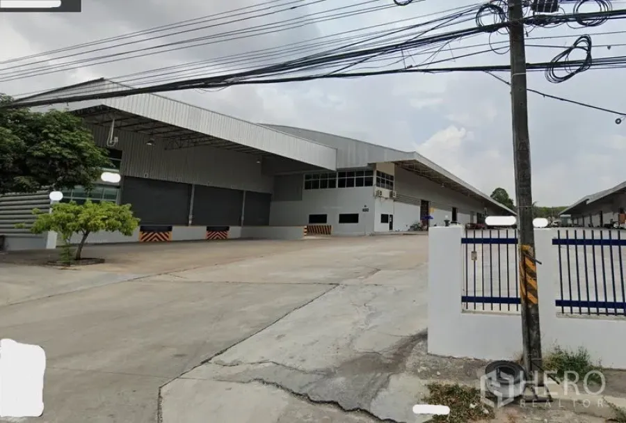 คลังสินค้า ให้เช่าในSi Racha, Chon Buri - ภายนอกโกดังสมัยใหม่ในศรีราชา ชลบุรี มีหลังคาคลุมช่องโหลด ลานคอนกรีตกว้าง และประตูรั้ว