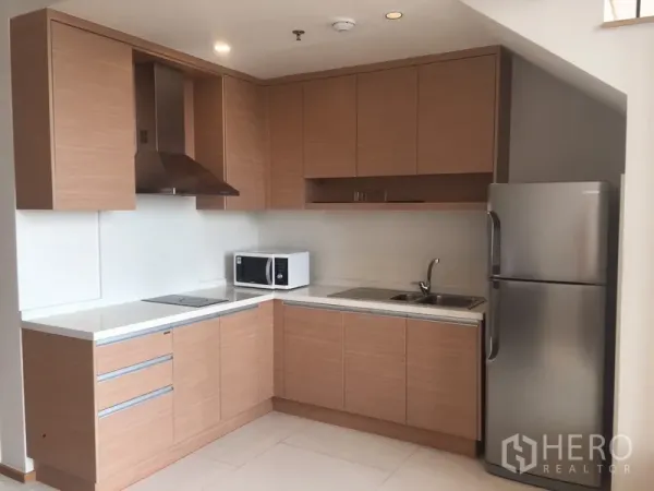 คอนโด ให้เช่าในKhlong Toei, Bangkok - ครัวตัวแอลสมัยใหม่ ตู้ไม้โทนอ่อน เครื่องดูดควัน เตา ซิงก์ ไมโครเวฟ และตู้เย็น