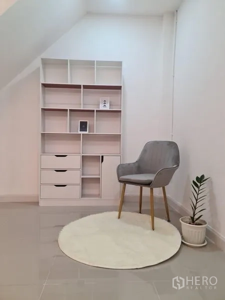 ทาวน์เฮาส์ ให้เช่าในKhlong Toei, Bangkok - มุมทำงาน/อ่านหนังสือ พร้อมชั้นวางของ เก้าอี้สีเทา พรมกลม และกระถางต้นไม้