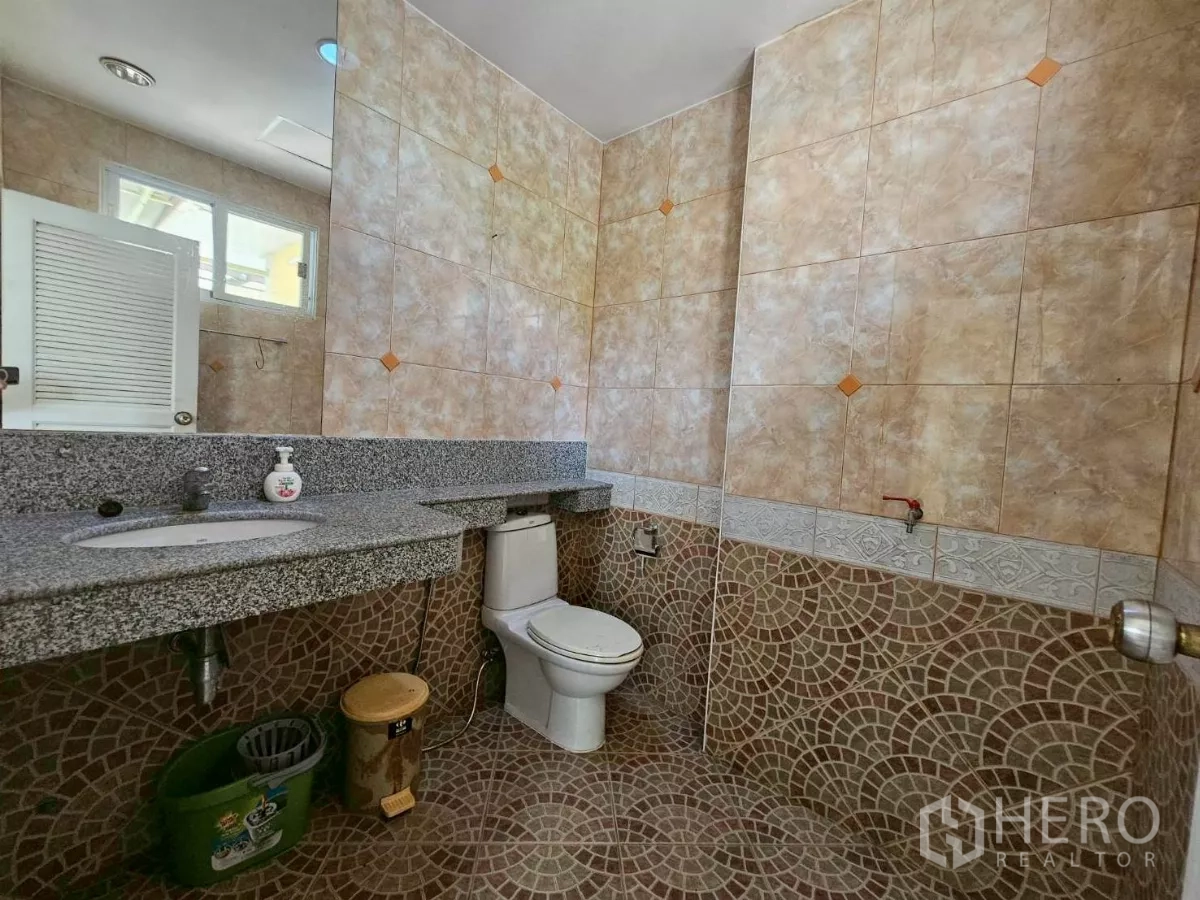 Detached House for rent or sale in Bang Lamung, Chon Buri - Ground-floor bathroom with granite counter, large mirror, and toilet.