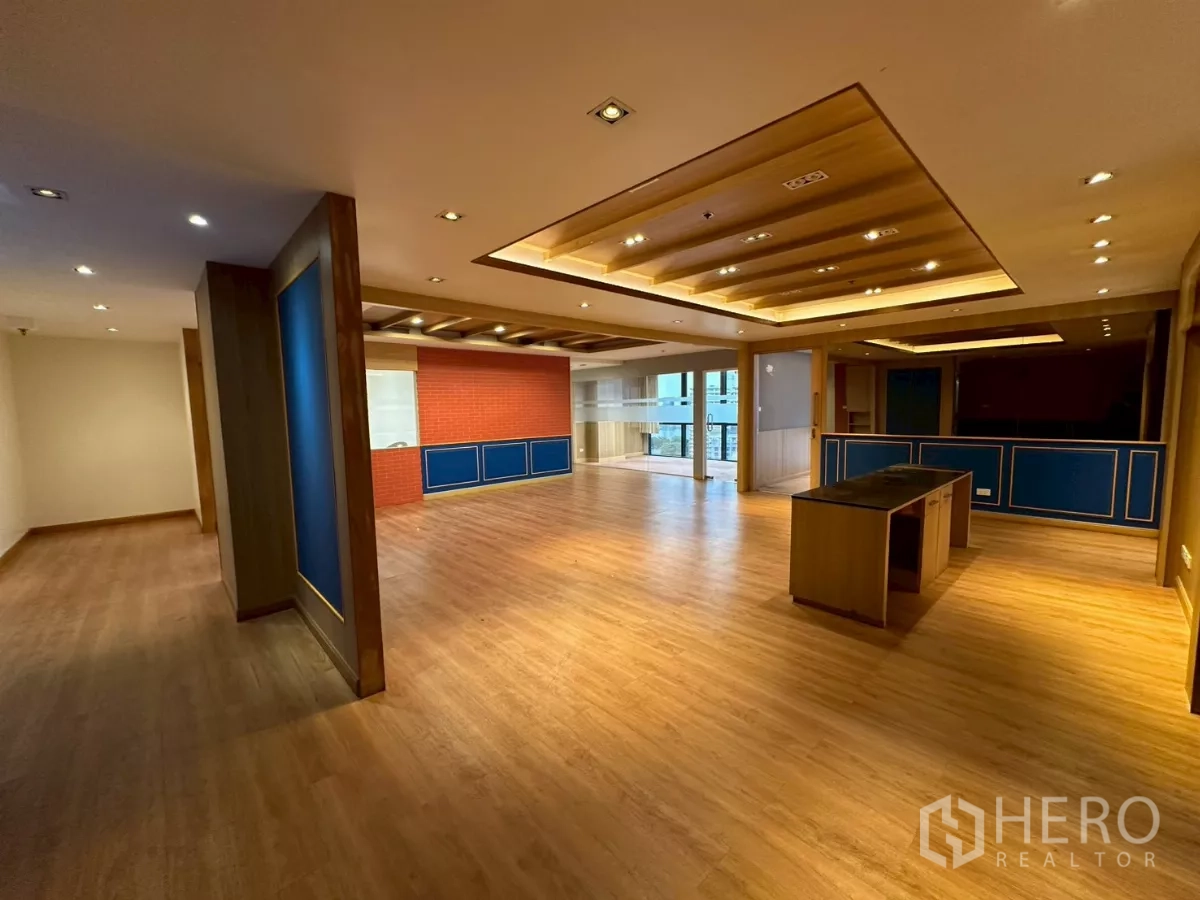 Office Space for rent in Khlong Toei, Bangkok - Spacious open-plan office with wood floors, coffered ceiling lights, and a reception island.