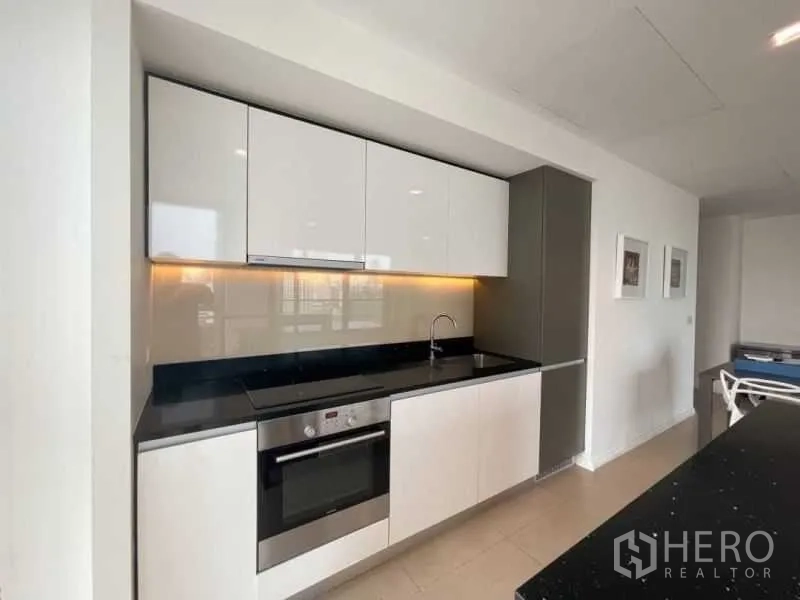 คอนโด ให้เช่าหรือขายในKhlong San, Bangkok - ครัวบิวท์อินสวยหรู ตู้ลายเงา เตาและเตาอบ พร้อมท็อปหินสีดำ