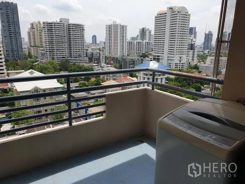 Condominium for rent in Watthana, Bangkok - Balcony corner with washing machine and open city views over high-rise buildings.