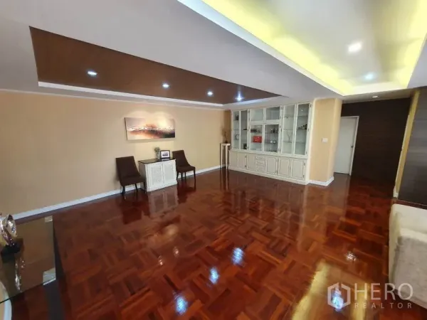 Condominium for rent in Watthana, Bangkok - Open-plan living area with recessed ceiling lights and built-in display cabinets.