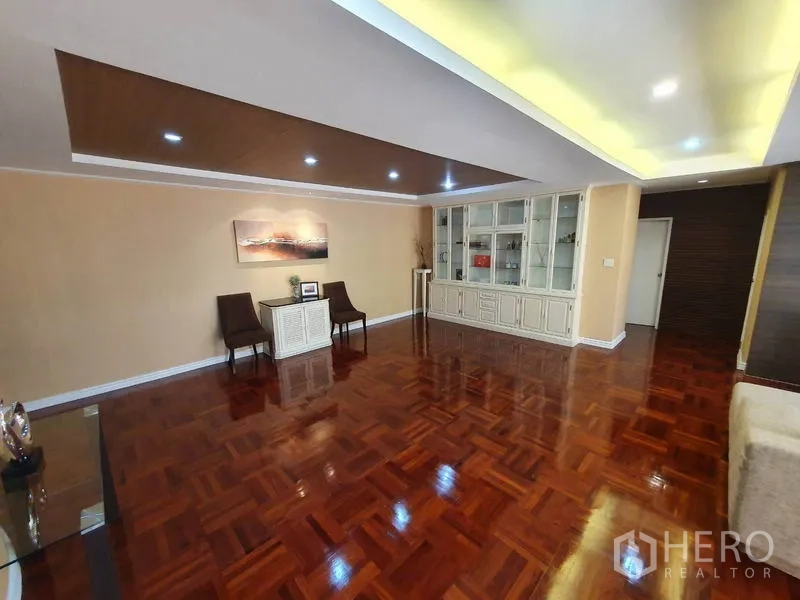 Condominium for rent in Watthana, Bangkok - Open-plan living area with recessed ceiling lights and built-in display cabinets.