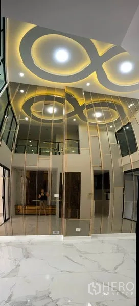 ทาวน์เฮาส์ ให้เช่าหรือขายในYan Nawa, Bangkok - ห้องนั่งเล่นเพดานสูงสองชั้น มีผนังกระจกเงาและไฟฝังทรงวงกลม