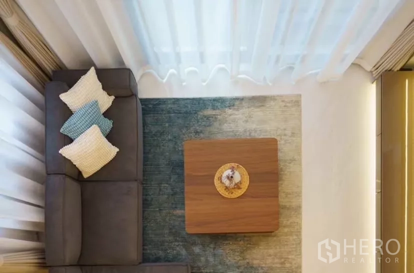 Detached House for rent or sale in Bang Phli, Samut Prakan - Top-down view of cozy seating corner with sectional sofa, rug and square coffee table.
