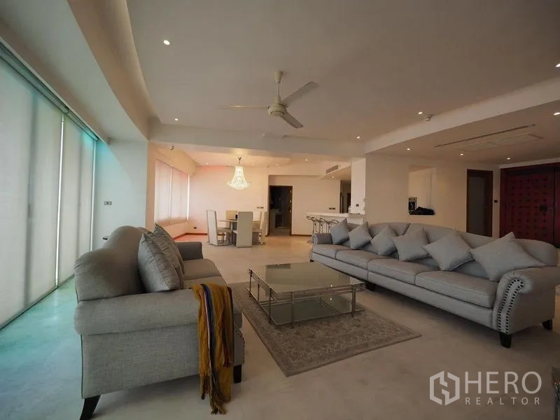 คอนโด ให้เช่าในKhlong San, Bangkok - ห้องนั่งเล่นกว้าง โซฟาสีเทา 2 ตัว พัดลมเพดาน และโต๊ะกลางกระจก