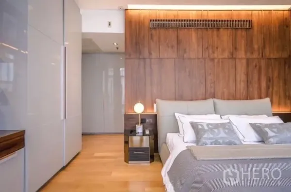 公寓 出租或出售 - 主卧带木饰面墙与柔和灯光，床头柜一体。