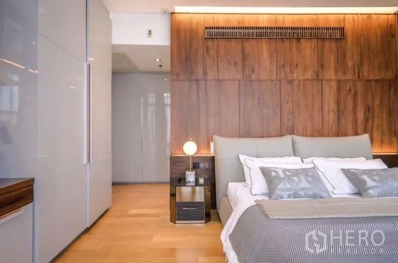 公寓 出租或出售 - 主卧带木饰面墙与柔和灯光，床头柜一体。