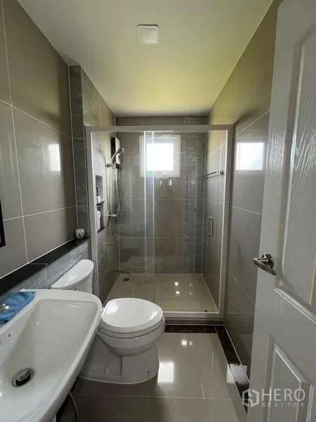 Detached House for rent or sale - Modern bathroom with glass-enclosed shower, toilet and sink.