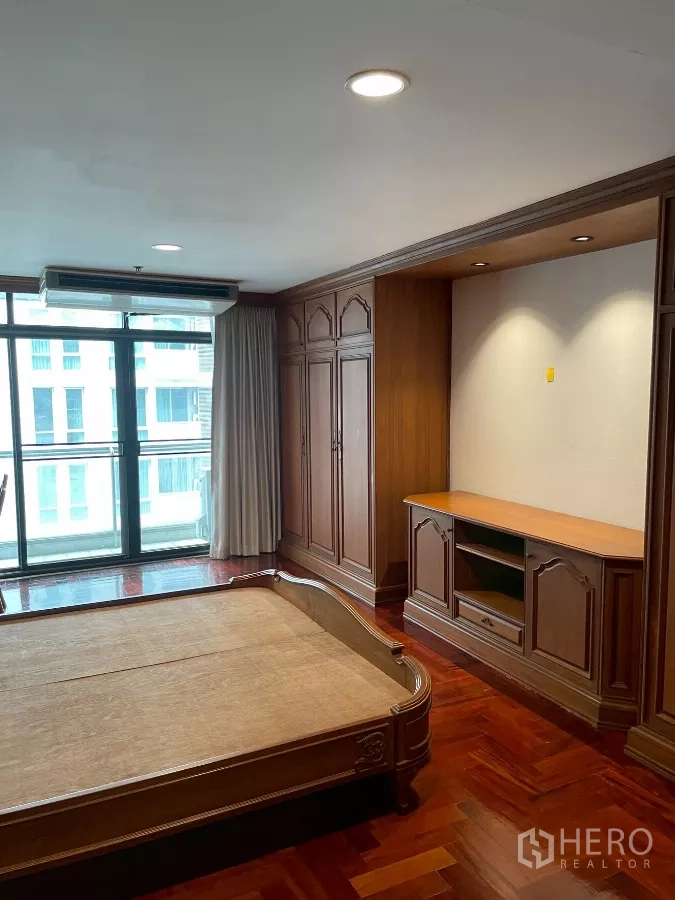 คอนโด ขายในWatthana, Bangkok - ห้องนอนใหญ่ ตู้บิลต์อินไม้ ชุดวางทีวี และประตูกระจกออกระเบียง