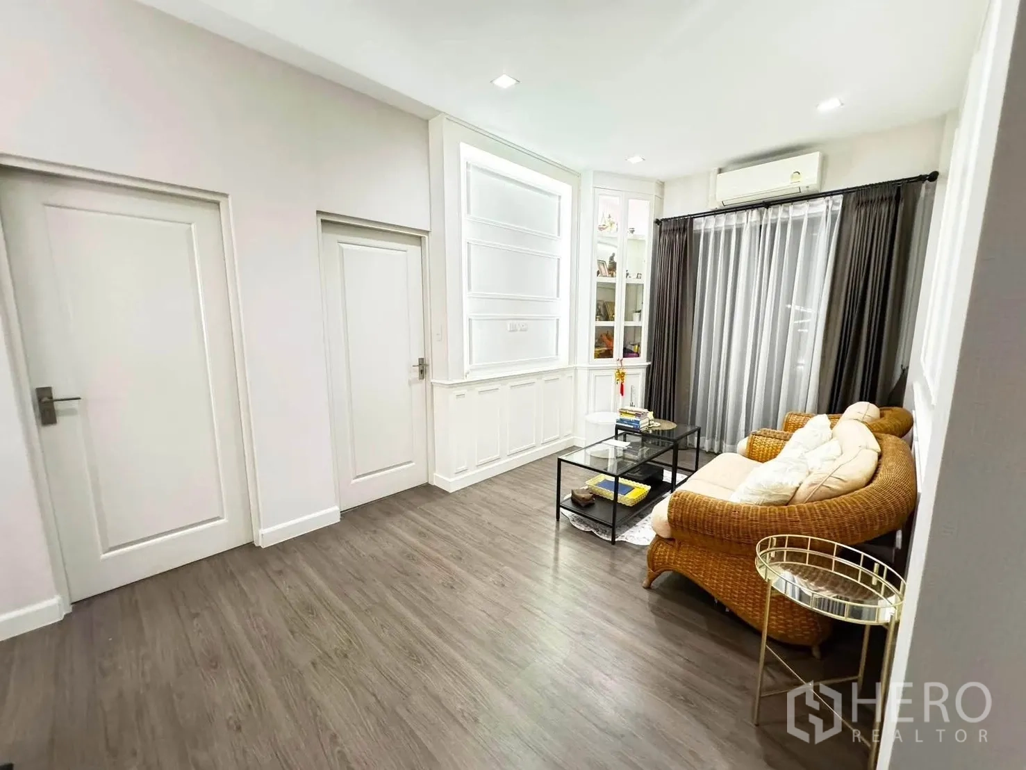 独栋房屋 for rent in Saphan Sung, Bangkok - 温馨起居角，藤编沙发、玻璃茶几与落地窗帘。
