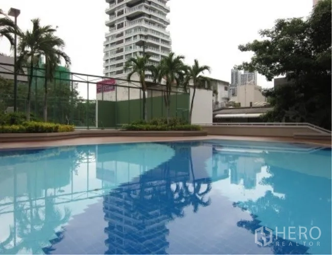 Condominium for rent in Watthana, Bangkok - Condominium outdoor swimming pool with palm trees, landscaped deck and city views in Watthana, Bangkok.