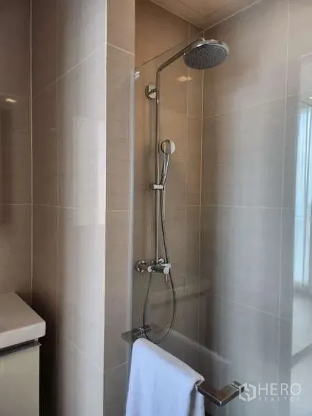 คอนโด ให้เช่าในKhlong Toei, Bangkok - ห้องน้ำกระเบื้องโทนอ่อน พร้อมฉากกั้นอาบน้ำและฝักบัวเรนชาวเวอร์