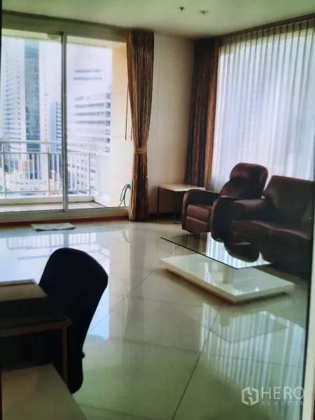 Condominium for rent or sale in Sathon, Bangkok - Bright living room with glossy tiled floors, floor‑to‑ceiling windows and sliding doors to the balcony.