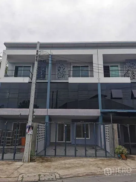 Home Office for rent or sale - Three-storey home office exterior with glass facade and gated parking.