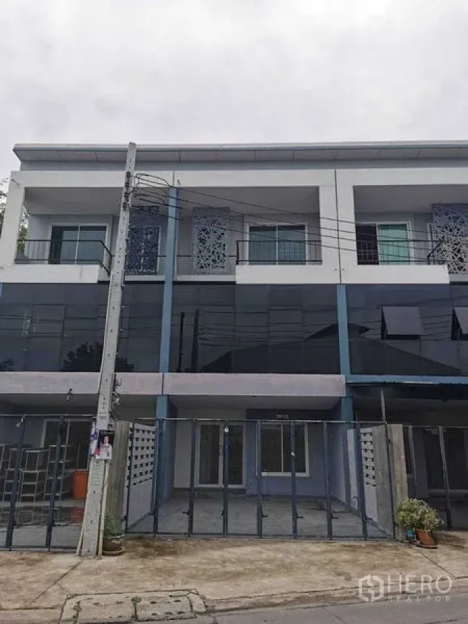 Home Office for rent or sale - Three-storey home office exterior with glass facade and gated parking.